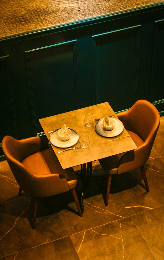 A stylish dining setup with two contemporary chairs and tableware in a modern restaurant.